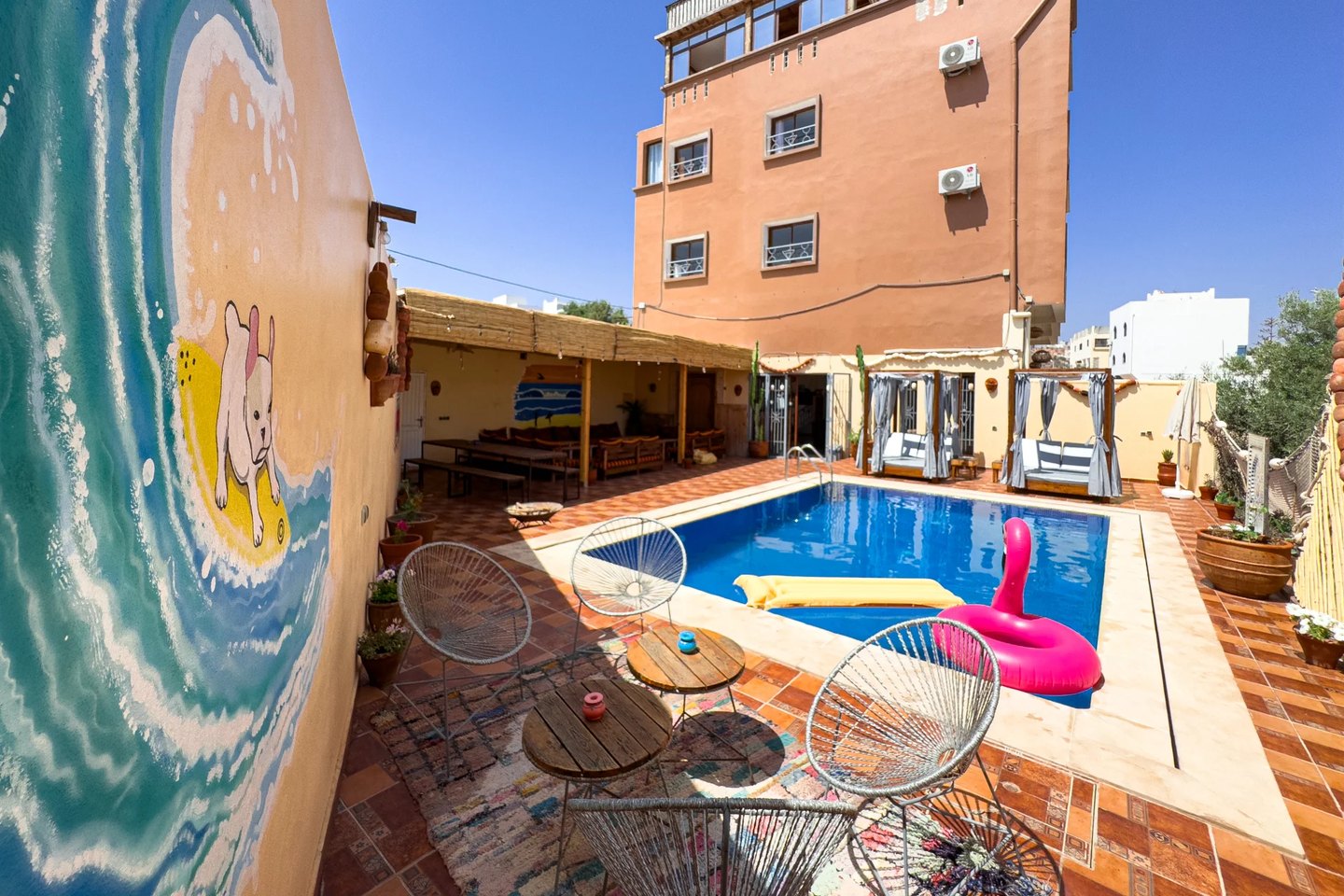 Sun House Morocco à Taghazout : la maison ocre, la piscine et la fresque de vague au soleil